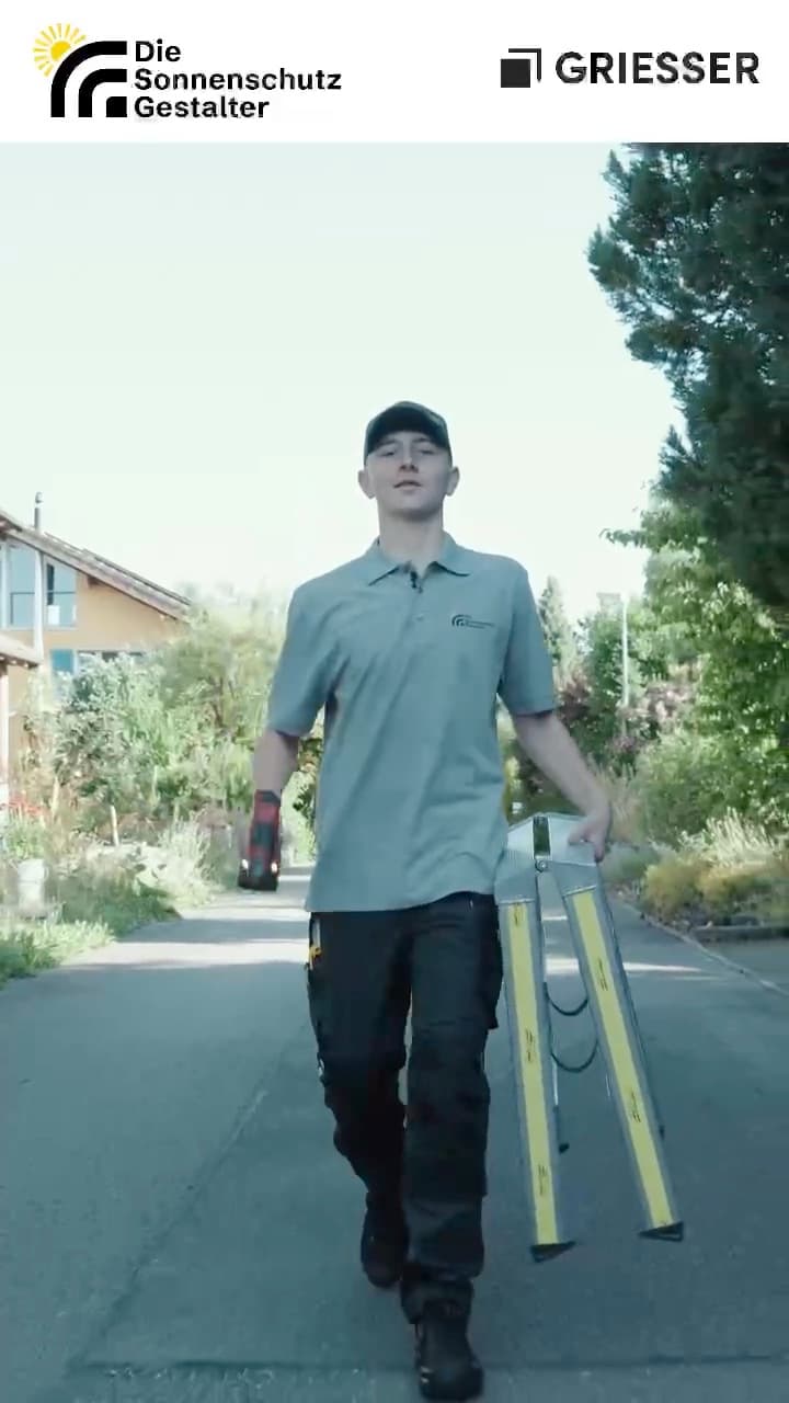 Lernender mit Leiter auf dem Weg zur Baustelle